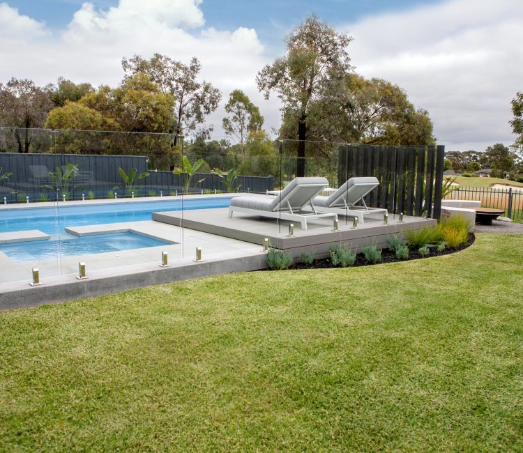 Fibreglass pool and spa combination by Master Pools with frameless glass fencing and composite decking in a Melbourne backyard